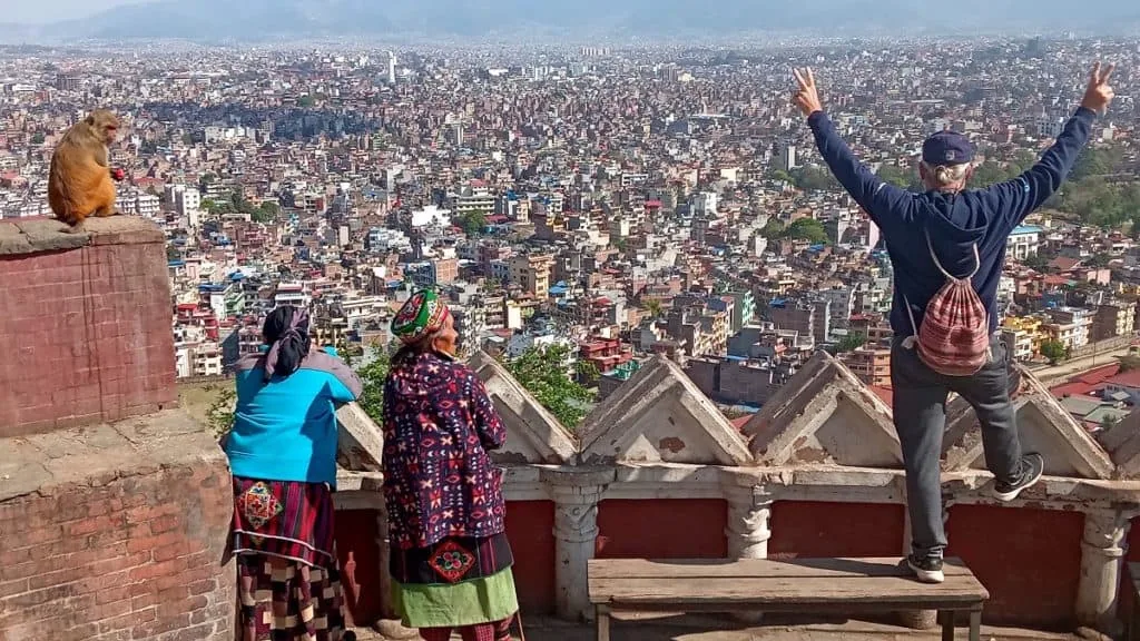 View over Kathmandu from a temple terrace in Nepal, with travellers looking across the valley